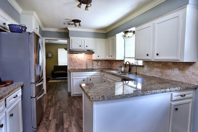 5926 Lattimer Dr, Houston, TX 77035 - kitchen with freestanding refrigerator, under cabinet range hood, white cabinets, decorative backsplash, and ornamental molding