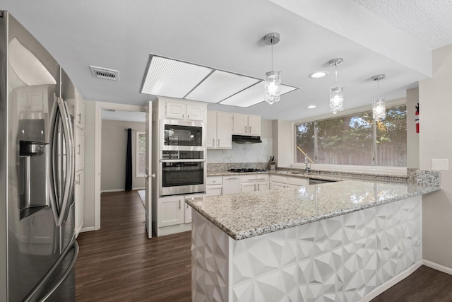 9827 Gold Cup Way, Houston, TX 77065 - kitchen with appliances with stainless steel finishes, a peninsula, under cabinet range hood, dark wood-style floors, and light stone counters