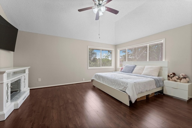 9827 Gold Cup Way, Houston, TX 77065 - bedroom featuring vaulted ceiling, wood finished floors, a ceiling fan, a textured ceiling, and a fireplace with raised hearth