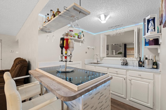9827 Gold Cup Way, Houston, TX 77065 - kitchen featuring open shelves, a textured ceiling, white cabinetry, a kitchen breakfast bar, and dark wood finished floors