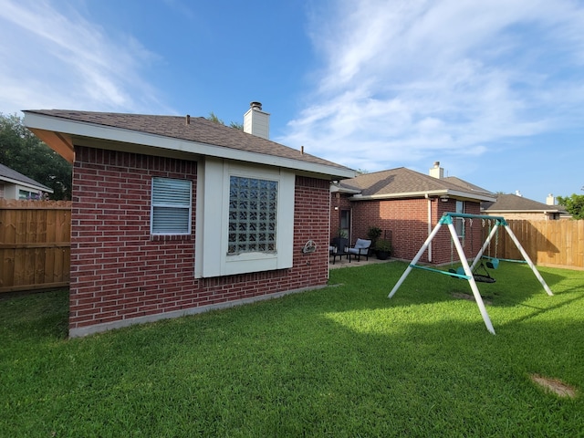 3214 Worthington Dr, Pearland, TX 77584 - rear view of property with a playground, brick siding, a chimney, and a patio