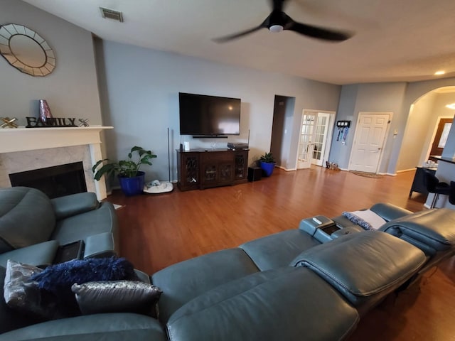 3214 Worthington Dr, Pearland, TX 77584 - living room featuring a ceiling fan, arched walkways, wood finished floors, and a fireplace