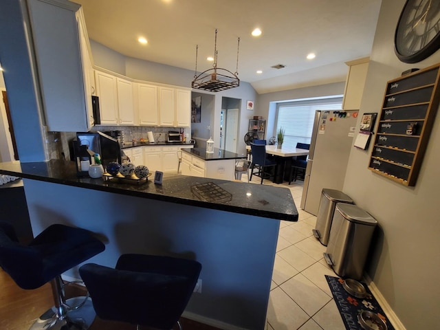3214 Worthington Dr, Pearland, TX 77584 - kitchen with freestanding refrigerator, a peninsula, dark countertops, backsplash, and light tile patterned floors