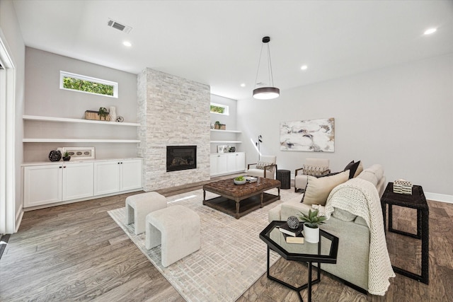 2065 Southgate Blvd, Houston, TX 77030 - living area with a fireplace, wood finished floors, built in shelves, and recessed lighting