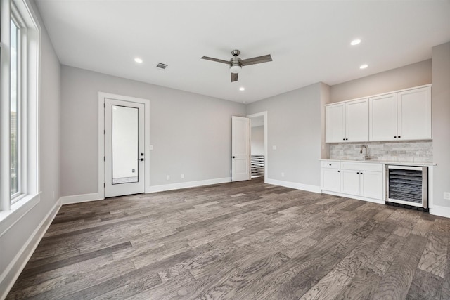 2065 Southgate Blvd, Houston, TX 77030 - unfurnished living room with beverage cooler, bar area, wood finished floors, a ceiling fan, and recessed lighting