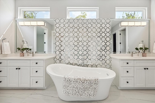 2065 Southgate Blvd, Houston, TX 77030 - bathroom with marble look tile flooring, two vanities, and a freestanding bath