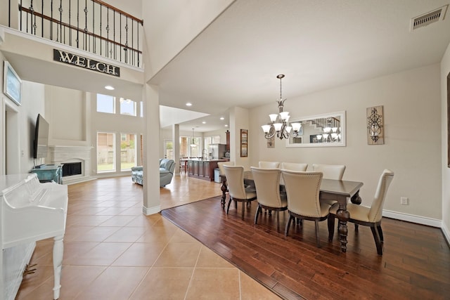 19831 Indigo Key Ct, Cypress, TX 77433 - dining room featuring a chandelier, wood finished floors, a fireplace, and recessed lighting