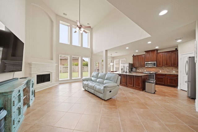 19831 Indigo Key Ct, Cypress, TX 77433 - living room with ceiling fan, light tile patterned flooring, a fireplace, recessed lighting, and a high ceiling