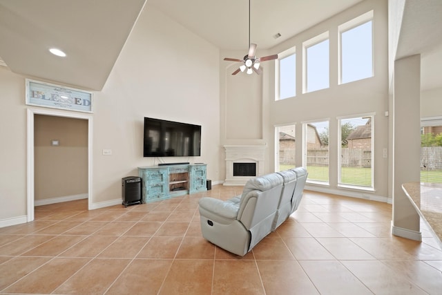 19831 Indigo Key Ct, Cypress, TX 77433 - living area with a towering ceiling, light tile patterned flooring, a ceiling fan, a fireplace with raised hearth, and recessed lighting