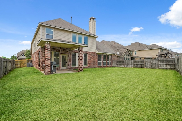 19831 Indigo Key Ct, Cypress, TX 77433 - rear view of house featuring brick siding, a chimney, a fenced backyard, a patio, and roof with shingles
