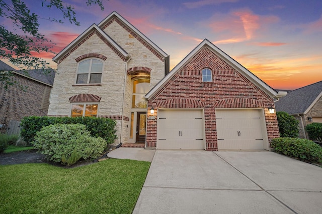 19831 Indigo Key Ct, Cypress, TX 77433 - french country inspired facade featuring stone siding, driveway, a garage, a lawn, and brick siding