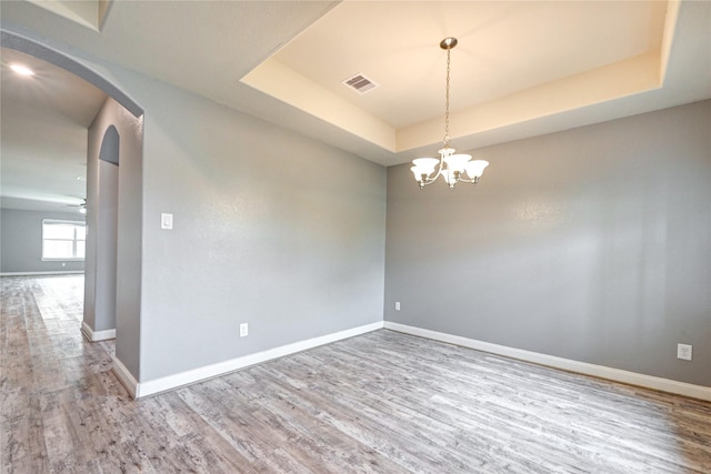 11442 Harmony Summit Trce, Richmond, TX 77406 - unfurnished room with wood finished floors, arched walkways, a raised ceiling, and a chandelier