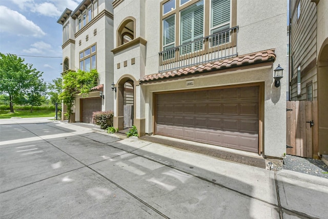 6107 Stillman St, Houston, TX 77007 - view of front of property with stucco siding, a garage, and a tile roof