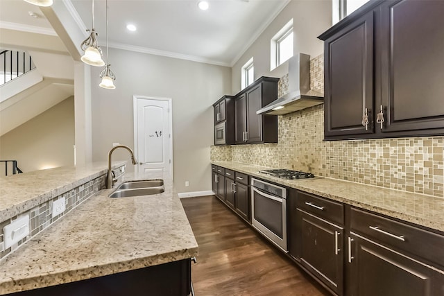 6107 Stillman St, Houston, TX 77007 - kitchen featuring wall chimney range hood, appliances with stainless steel finishes, crown molding, decorative backsplash, and dark wood finished floors