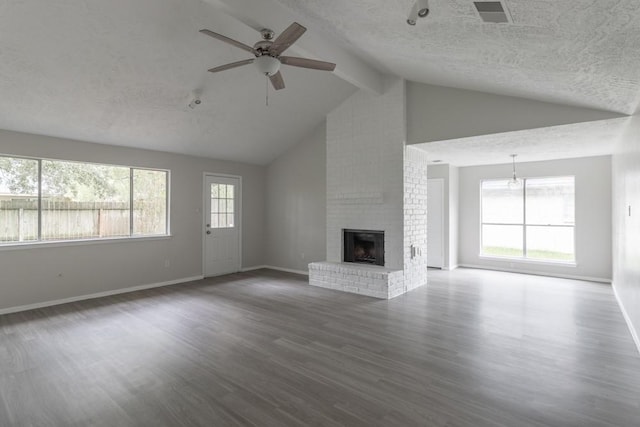 15803 Cerca Blanca Dr, Houston, TX 77083 - unfurnished living room featuring a textured ceiling, beamed ceiling, ceiling fan, a brick fireplace, and wood finished floors