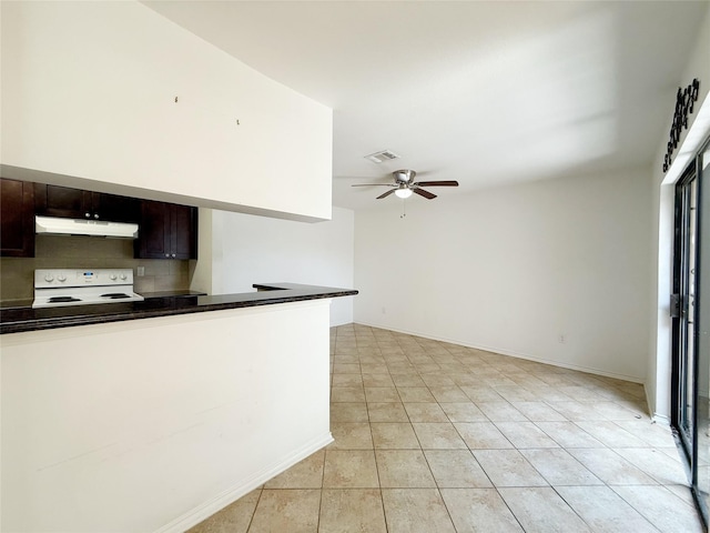 10912 Gulf Fwy Unit 68, Houston, TX 77034 - kitchen with white range with electric cooktop, under cabinet range hood, light tile patterned flooring, dark countertops, and a ceiling fan