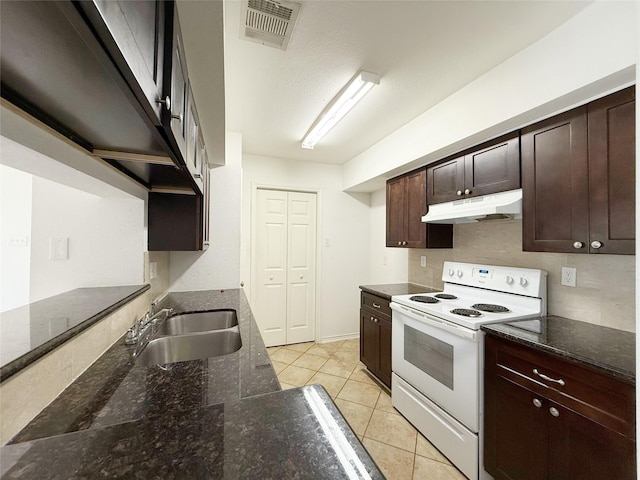 10912 Gulf Fwy Unit 68, Houston, TX 77034 - kitchen with white electric range, under cabinet range hood, light tile patterned floors, dark brown cabinets, and dark stone countertops