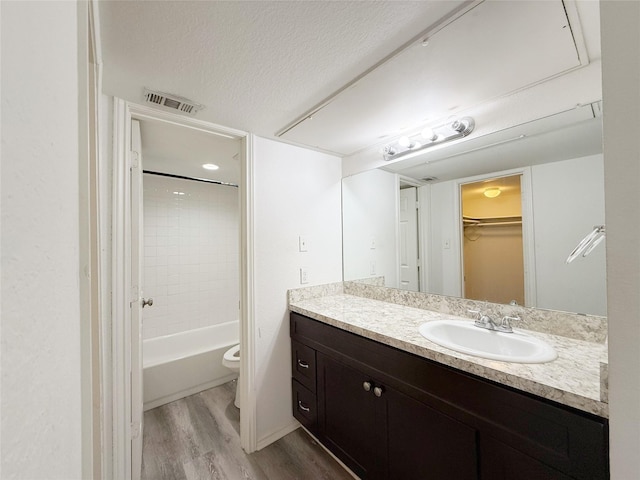 10912 Gulf Fwy Unit 68, Houston, TX 77034 - bathroom featuring vanity, wood finished floors, washtub / shower combination, a textured ceiling, and a spacious closet