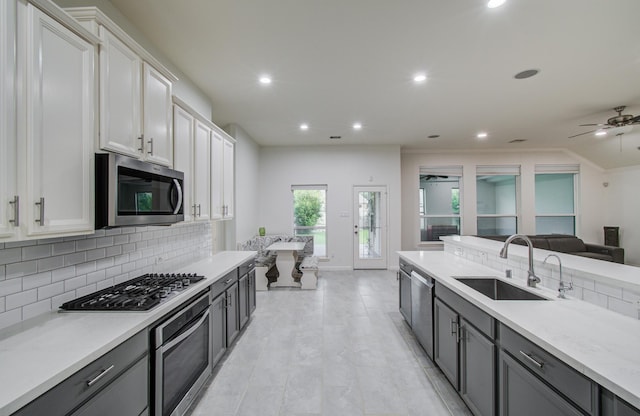 4639 Regal Shadow Ln, Sugar Land, TX 77479 - kitchen with stainless steel appliances, tasteful backsplash, recessed lighting, white cabinets, and open floor plan