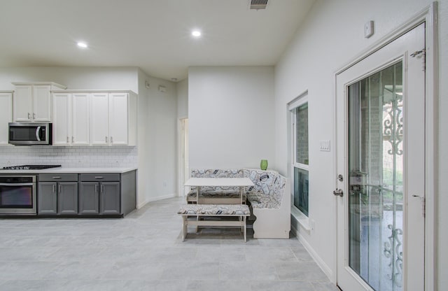 4639 Regal Shadow Ln, Sugar Land, TX 77479 - kitchen with appliances with stainless steel finishes, gray cabinetry, decorative backsplash, recessed lighting, and white cabinets