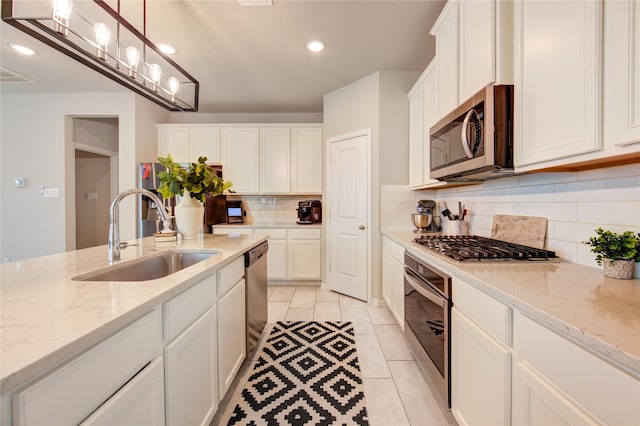 17715 White Lightning Way, Spring, TX 77379 - kitchen with appliances with stainless steel finishes, tasteful backsplash, white cabinets, recessed lighting, and hanging light fixtures