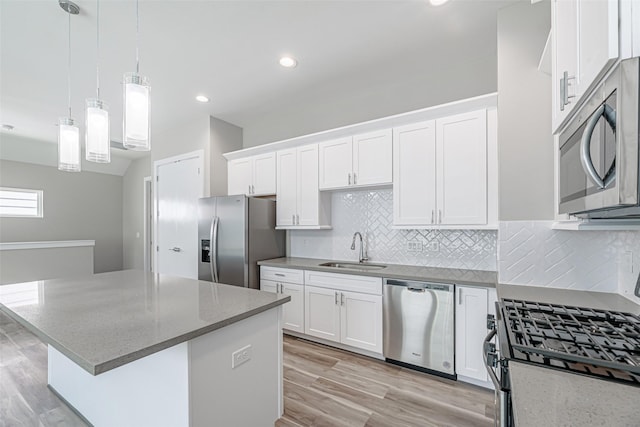 240 Julia St Unit D, Houston, TX 77022 - kitchen with stainless steel appliances, white cabinetry, a kitchen island, decorative backsplash, and light wood finished floors