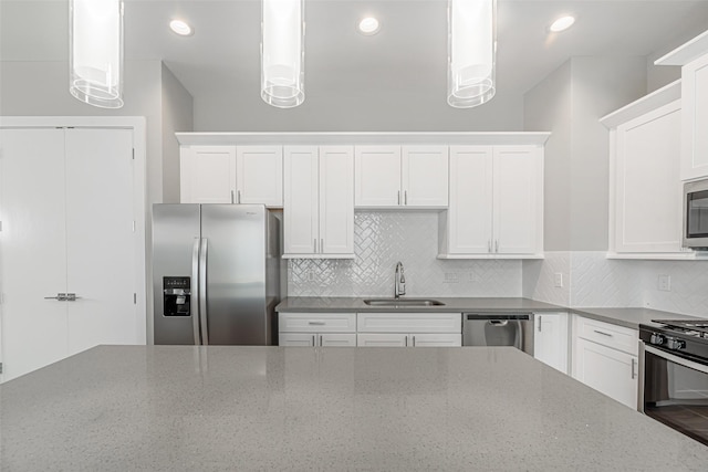 240 Julia St Unit D, Houston, TX 77022 - kitchen with appliances with stainless steel finishes, white cabinets, tasteful backsplash, pendant lighting, and stone counters