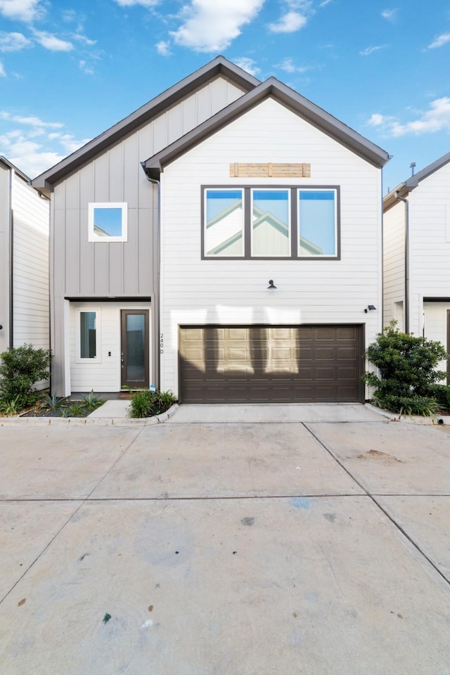 240 Julia St Unit D, Houston, TX 77022 - view of front facade featuring driveway, board and batten siding, and an attached garage