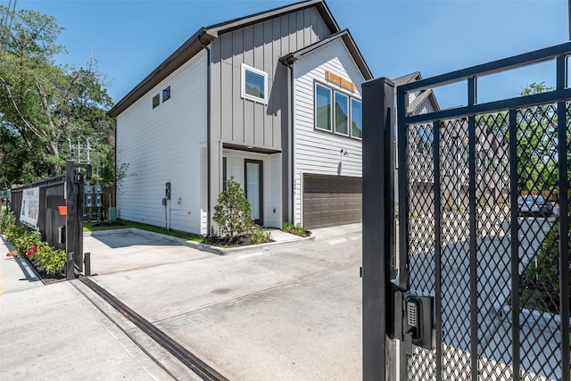 240 Julia St Unit D, Houston, TX 77022 - view of side of home featuring a garage, concrete driveway, and board and batten siding