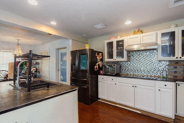 117 Pecan Dr, Baytown, TX 77520 - kitchen featuring stainless steel fridge with ice dispenser, under cabinet range hood, black stovetop, dark countertops, and white cabinets