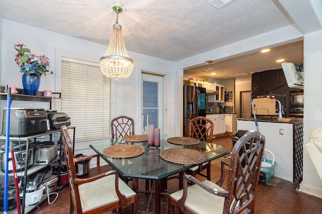 117 Pecan Dr, Baytown, TX 77520 - dining room with a chandelier, dark wood-type flooring, a textured ceiling, and recessed lighting