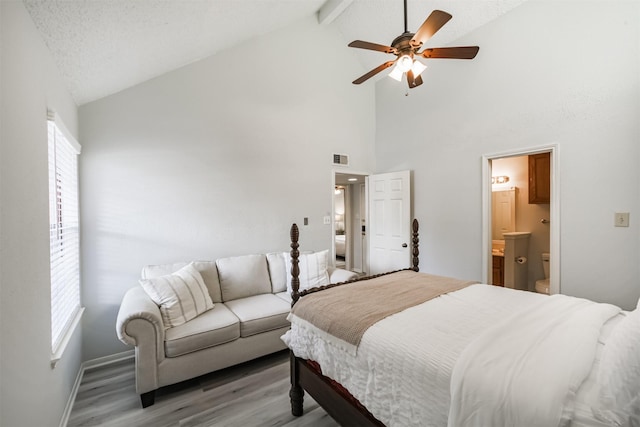 2300 Old Spanish Trl Unit 1060, Houston, TX 77054 - bedroom featuring light wood-style floors, high vaulted ceiling, beam ceiling, ensuite bathroom, and a ceiling fan