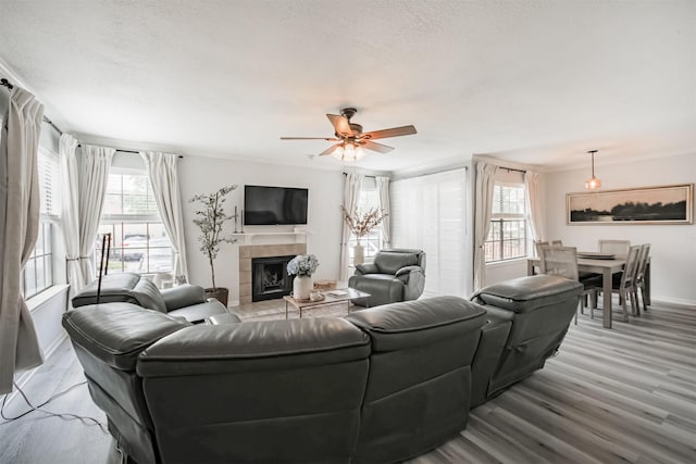 2300 Old Spanish Trl Unit 1060, Houston, TX 77054 - living room featuring wood finished floors, a fireplace, a ceiling fan, and a textured ceiling