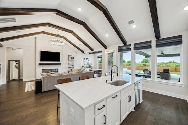 14115 Garibaldi Dr, Cypress, TX 77433 - kitchen featuring dark wood-style flooring, white cabinets, a fireplace, an island with sink, and recessed lighting