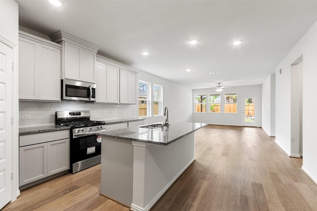 4402 Azalea Blossom Rd, Pinehurst, TX 77362 - kitchen with stainless steel appliances, recessed lighting, stone countertops, light wood-style flooring, and backsplash