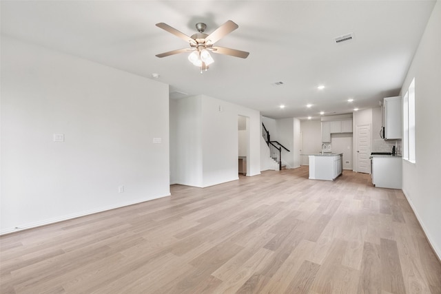 4402 Azalea Blossom Rd, Pinehurst, TX 77362 - unfurnished living room featuring recessed lighting, a ceiling fan, light wood-style flooring, and stairs