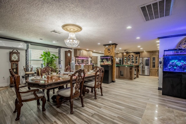 2019 Vanamen Ct, Conroe, TX 77304 - dining area featuring a textured ceiling, recessed lighting, light wood-type flooring, and a chandelier