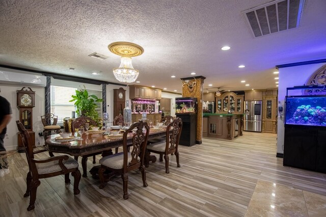 2019 Vanamen Ct, Conroe, TX 77304 - dining space featuring a textured ceiling, recessed lighting, a chandelier, and light wood-style flooring