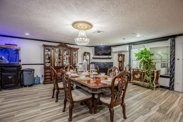 2019 Vanamen Ct, Conroe, TX 77304 - dining space with a textured ceiling, a fireplace, light wood-style flooring, an AC wall unit, and a chandelier