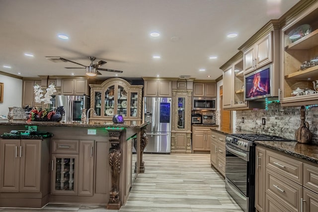 2019 Vanamen Ct, Conroe, TX 77304 - kitchen featuring stainless steel appliances, ceiling fan, recessed lighting, dark stone counters, and decorative backsplash
