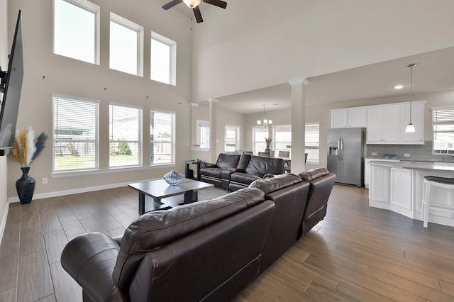 3604 Magnolia Crest Ln, Spring, TX 77386 - living area with decorative columns, a ceiling fan, a chandelier, dark wood-type flooring, and healthy amount of natural light
