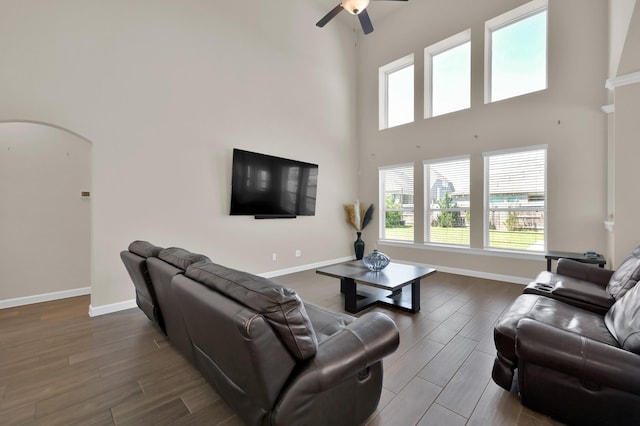 3604 Magnolia Crest Ln, Spring, TX 77386 - living room featuring a towering ceiling, dark wood finished floors, arched walkways, ceiling fan, and healthy amount of natural light