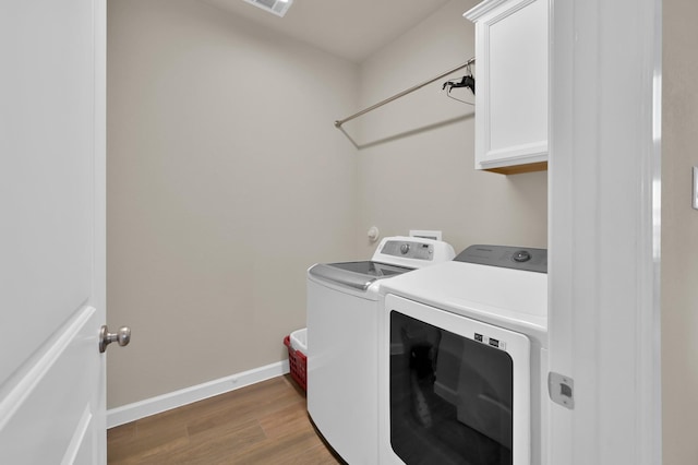 3604 Magnolia Crest Ln, Spring, TX 77386 - laundry room featuring washer and clothes dryer, cabinet space, and wood finished floors