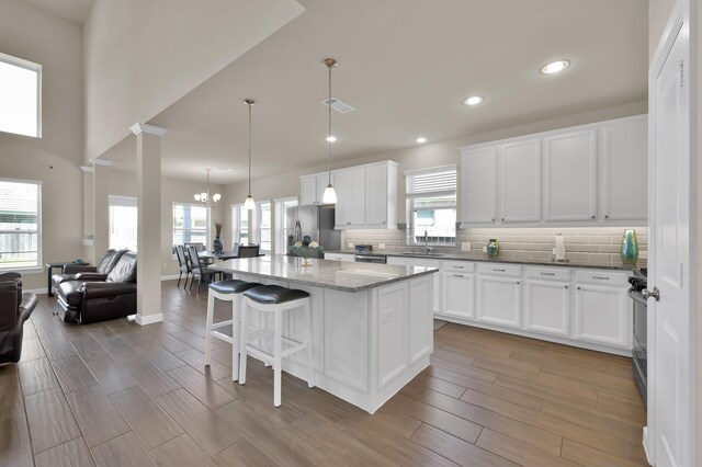 3604 Magnolia Crest Ln, Spring, TX 77386 - kitchen featuring open floor plan, stainless steel appliances, a kitchen bar, tasteful backsplash, and white cabinets