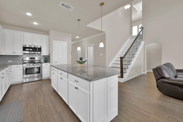 3604 Magnolia Crest Ln, Spring, TX 77386 - kitchen with appliances with stainless steel finishes, wood finished floors, tasteful backsplash, open floor plan, and crown molding