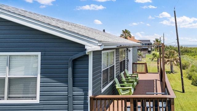 4039 San Jacinto Dr, Galveston, TX 77554 - view of side of home featuring a shingled roof and a deck