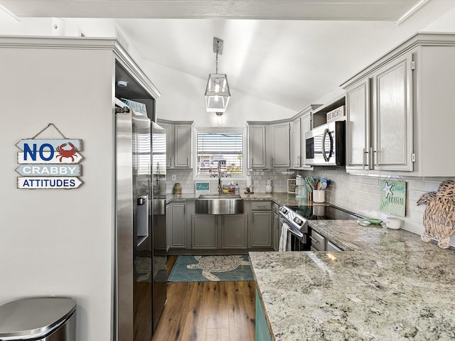 4039 San Jacinto Dr, Galveston, TX 77554 - kitchen featuring stainless steel appliances, gray cabinetry, backsplash, lofted ceiling, and dark wood finished floors