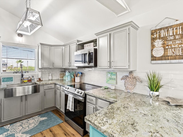 4039 San Jacinto Dr, Galveston, TX 77554 - kitchen featuring stainless steel appliances, gray cabinetry, decorative backsplash, lofted ceiling, and open shelves