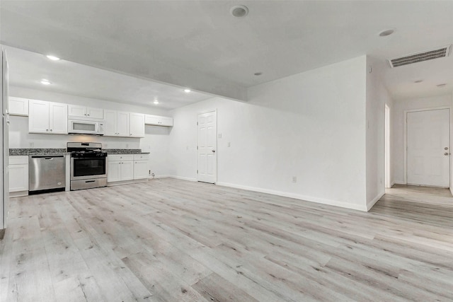 408 Commanche Rd, Conroe, TX 77316 - kitchen featuring appliances with stainless steel finishes, light wood finished floors, white cabinets, dark countertops, and recessed lighting