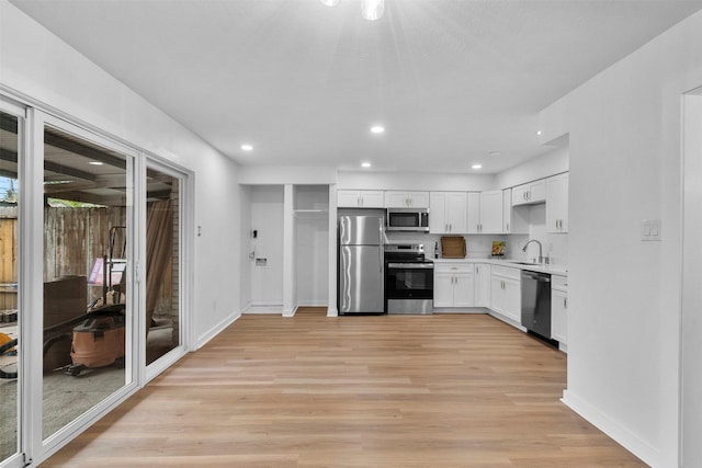 8124 Fondren Rd Unit 8124, Houston, TX 77074 - kitchen with stainless steel appliances, light countertops, light wood finished floors, white cabinets, and recessed lighting